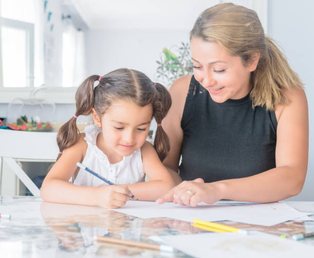istock Mother helping daughter with homework 1160818891