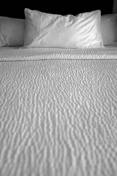Soft unmade bed with a white blanket and pillows after waking up
