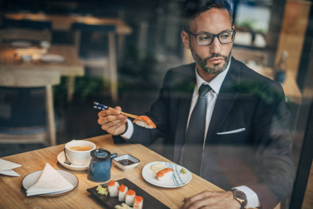 istock Man eating sushi in the restaurant 1160821324