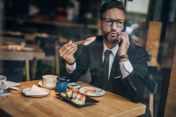 istock Man in the sushi restaurant using phone 1160821461