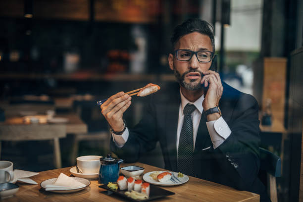 istock Man in the sushi restaurant using phone 1160821513