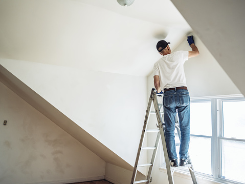 Retirement life. Time to downsize your home. Senior man painting apartment interior.