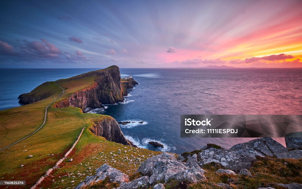 Neist point lighthouse, Isle of Skye, Scotland, UK Neist Point is one of the most famous lighthouses in Scotland and can be found on the most westerly tip of Skye near the township of Glendale. You will see stunning views of the high cliffs and the lighthouse itself, at sunset the view is made even more spectacular making this a top destination for landscape photographers. Here you can see the lighthouse during a beautiful sunset in October. Scotland Stock Photo