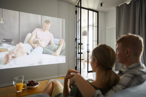 istock Young amorous couple watching their home video 1160825388