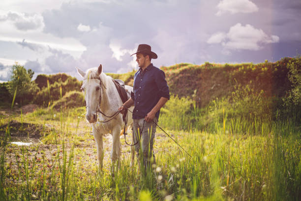 istock Handsome man and his mare horse 1160826714