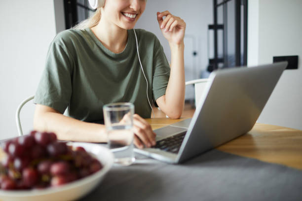 istock Smiling young woman networking in front of laptop 1160827261