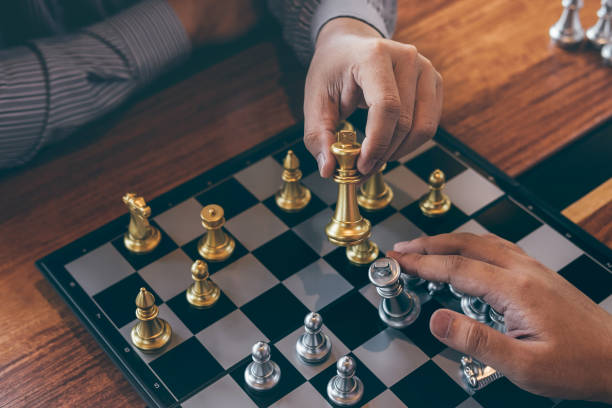 istock Intelligent businessman playing chess game competition with the opposite team, planning business strategic to development for win and success, Gold and silver chess with player 1160828381