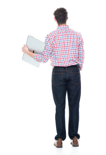 istock Attractive young man wearing a checked shirt and jeans - using a laptop 1160832290