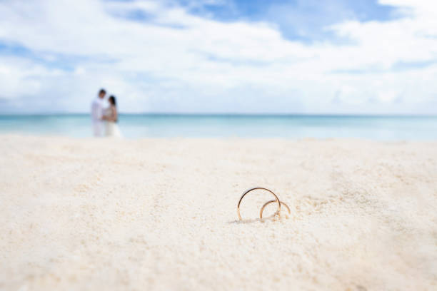 Wedding rings on the white sand. In the background the newlyweds and the ocean. Wedding rings on the white sand. In the background the newlyweds and the ocean. Wedding on a tropical island. snow white and the seven dwarfs photos stock pictures, royalty-free photos & images