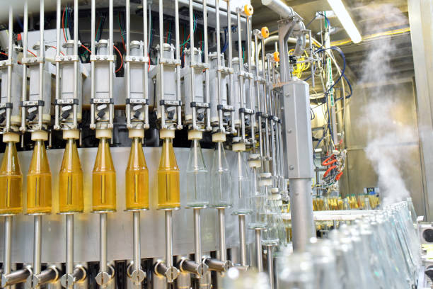 apple juice in glass bottles in a factory for the food industry - bottling and transport - food and drink industry imagens e fotografias de stock