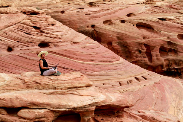 istock A woman working on laptop computer high up on rocks. 1160835802