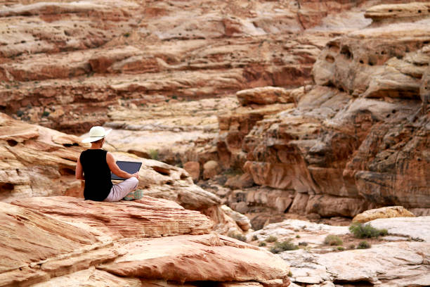 istock A woman working on laptop computer high up on rocks. 1160835941