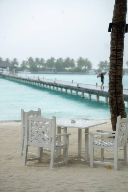 White table restaurant on the beach. The rainy season has begun.