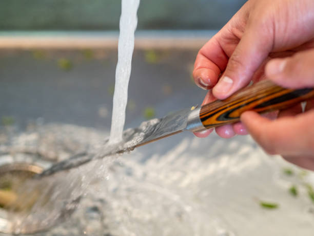 Man's hands washing under the tap a kitchen knife. Man's hands washing under the tap a kitchen knife craft knife stock pictures, royalty-free photos & images