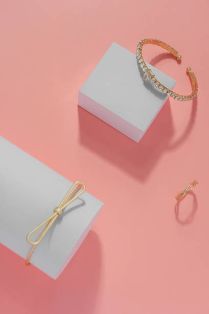 istock Vertical composition of Modern golden bracelets and ring on pink background 1160844512