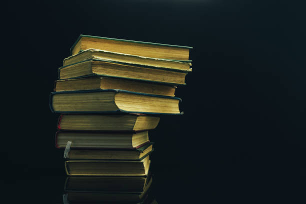 istock Old books on a glass table black background. 1160845534