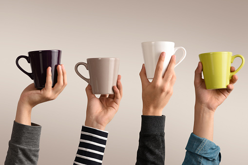 Group of different male hands holding colorful coffee cups