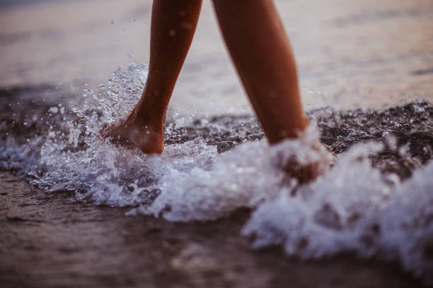 istock Woman walking on the beach 1160846726
