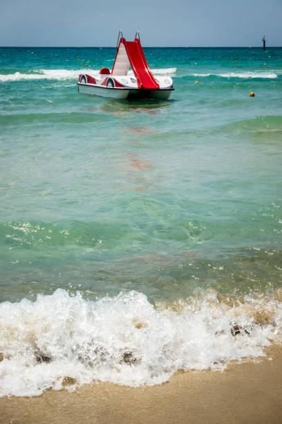 ein tretboot mit wasserrutschen am strand in chalkidiki, griechenland - pedal boat stock-fotos und bilder