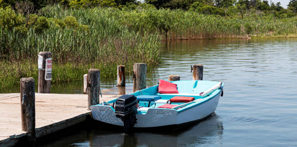 istock Small motorboat tied to a dock surrounded by beach grass 1160847923