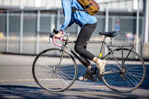 Woman rides a bike on city street. The use of a bicycle as the main transport for many enthusiasts has grown from a hobby into a vital necessity for maintaining health and environmental concerns