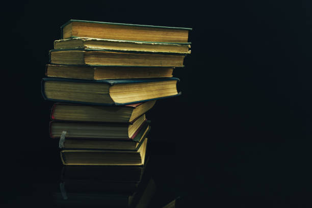 istock Old books on a glass table black background. 1160848922
