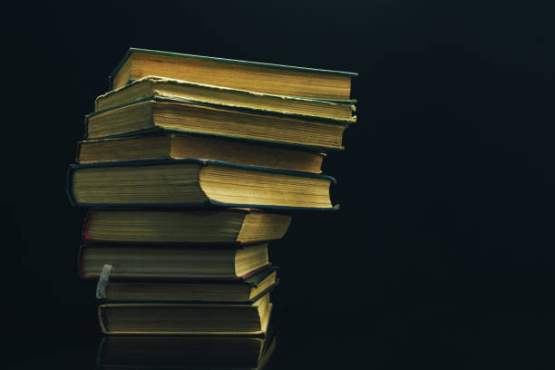 istock Old books on a glass table black background. 1160849809