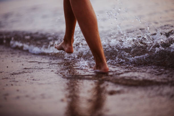 istock Woman walking on the beach 1160849879