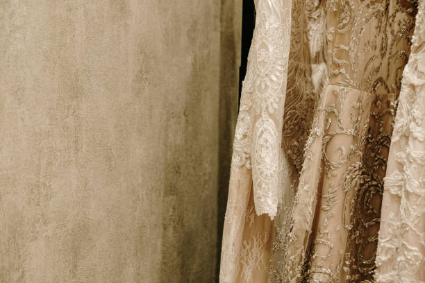 istock Cream wedding dresses hanging on the rack 1160850456