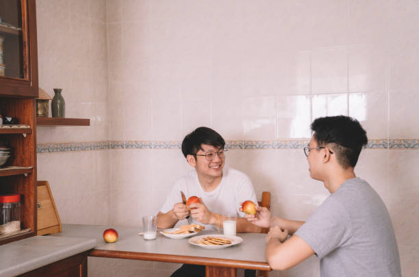 istock 2 asian chinese brother sibling having breakfast at dining table in the kitchen morning before they going to work 1160850460