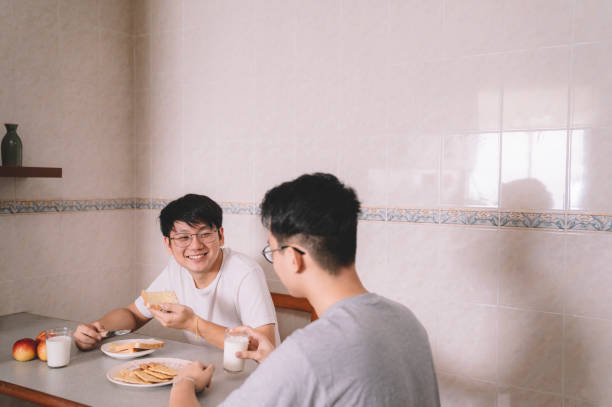 istock 2 asian chinese brother sibling having breakfast at dining table in the kitchen morning before they going to work 1160850462