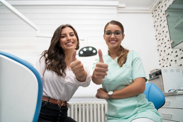 Nurse/dentist and her patient showing thumbs up