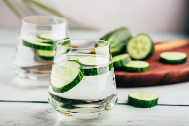 Water infused with sliced cucumber Water infused with sliced cucumber in a drinking glass cucumber photos stock pictures, royalty-free photos & images