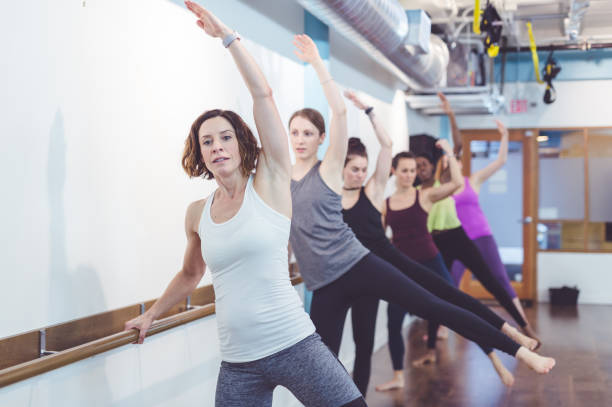 istock Instructor leads a multiethnic group of women through a barre workout 1160867064