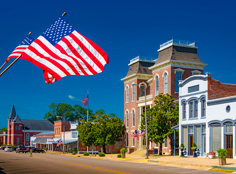 American Flags flying in a small town square.