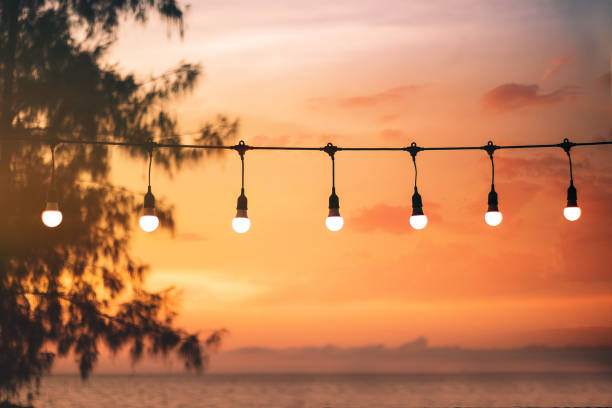 istock blurred bokeh light on sunset with yellow string lights decor in beach restaurant 1160875918