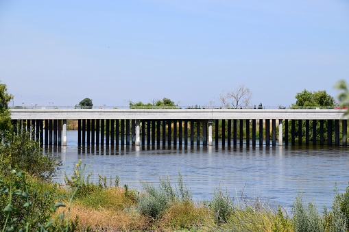 A bridge goes across Kern River in Bakersfield, CA. Kern river has plenty of flowing water during summer season.