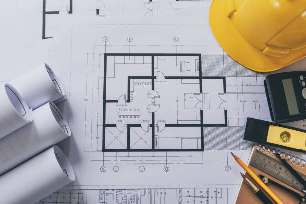 istock Architect house plan roled -up plans on the table, high angle view. 1160879571