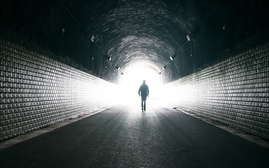 Young man in dark tunnel