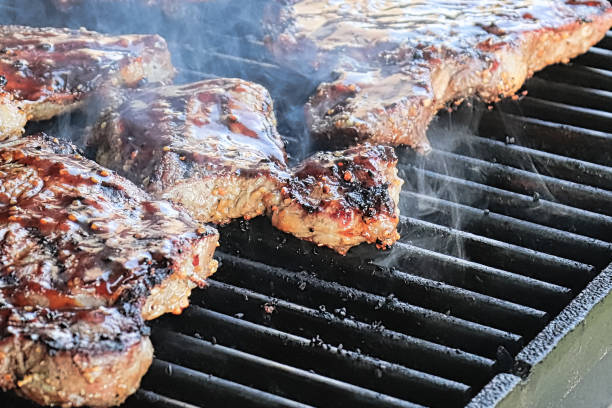 istock Closeup of steaks cooking on a BBQ 1160888659