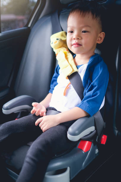 Asian 3 - 4 years old toddler boy child sitting in booster car seat, Happy traveling, Child passenger safety Cute little Asian 3 - 4 years old toddler boy child sitting in booster car seat, Happy traveling, Child passenger safety, Safe way to travel fastened seat belts in vehicle with young kid concept rocket booster photos stock pictures, royalty-free photos & images