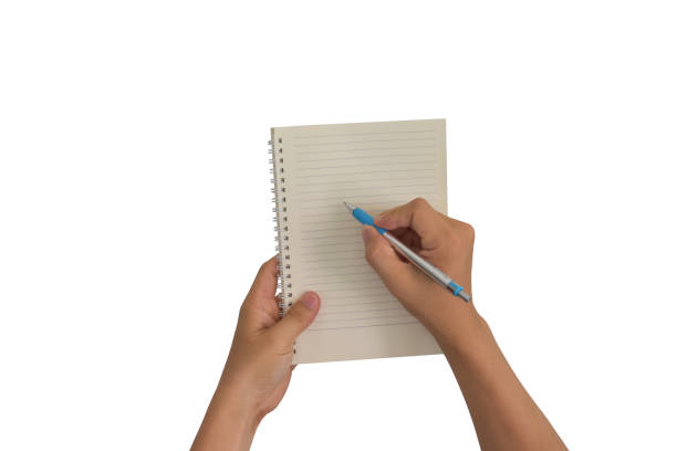 Stock photo showing close-up view of a single yellow adhesive note pad held in the palm of one hand of an unrecognisable person who is holding a black ball point pen in their other hand in order to take notes. Ideation, creative thinking and idea storming concept.