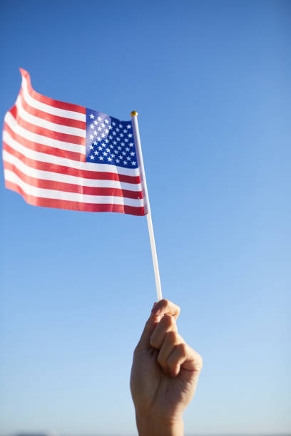 istock Raising hand with American flag on stick 1160894385