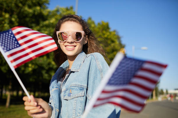 istock Jovial student girl with national flags 1160894392
