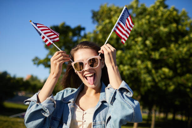 istock Playful girl posing with American flags 1160894396
