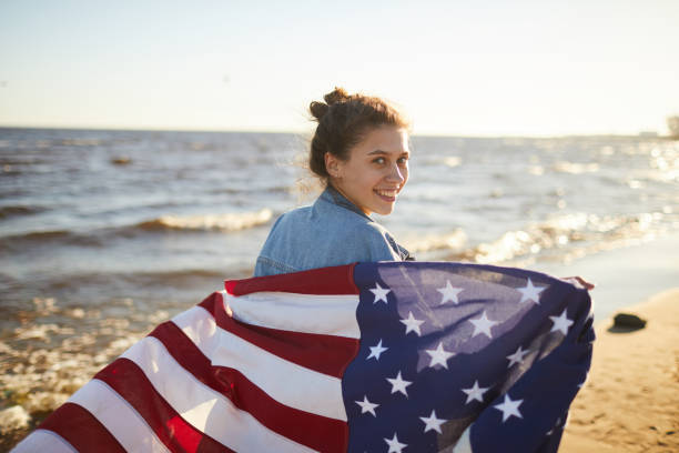 istock Smiling woman with big national flag 1160894405