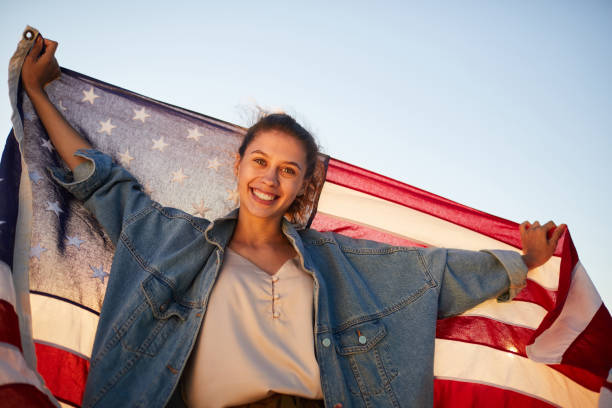 Excited young woman holding US flag