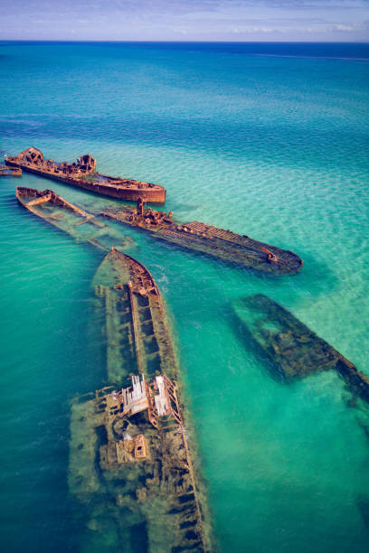 Tangalooma Wrecks from behind 3 The Tangalooma Wrecks used to be 15 steam driven barges which were deliberately sunk in 1963 along the Moreton Island coastline to form a breakwall so that small boats can anchor in shelter shades of blue stock pictures, royalty-free photos & images
