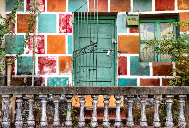 Stunning view of a traditional Indian home with a green wooden door and colorful traditional Indian clothes (Sari) hanging to dry. Blue City of Jodhpur, Rajasthan, India.