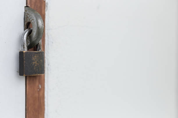 istock Old padlock on the white door and copy space 1160902136